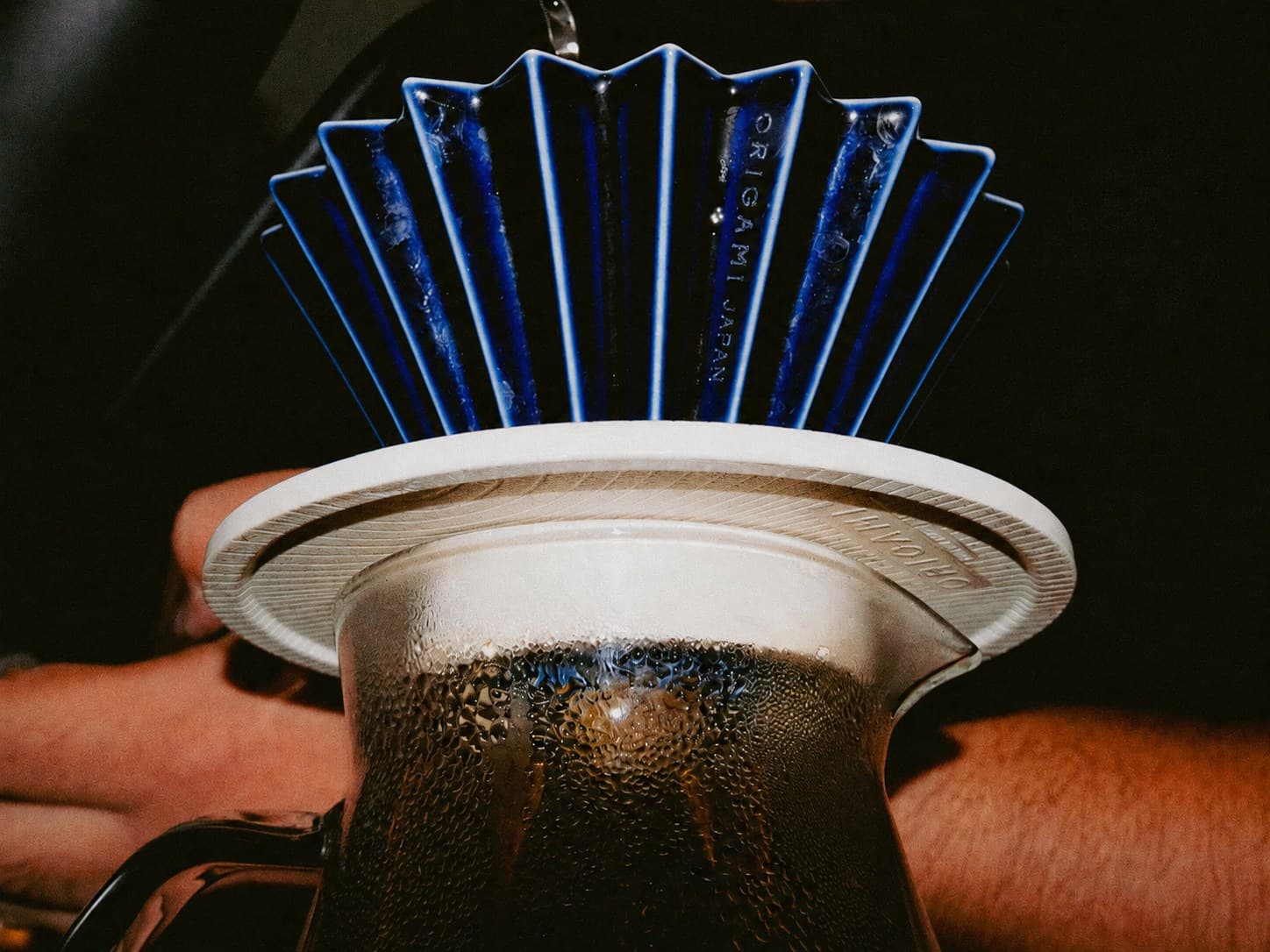 dripper origami azul sobre un server de vidrio en la barra